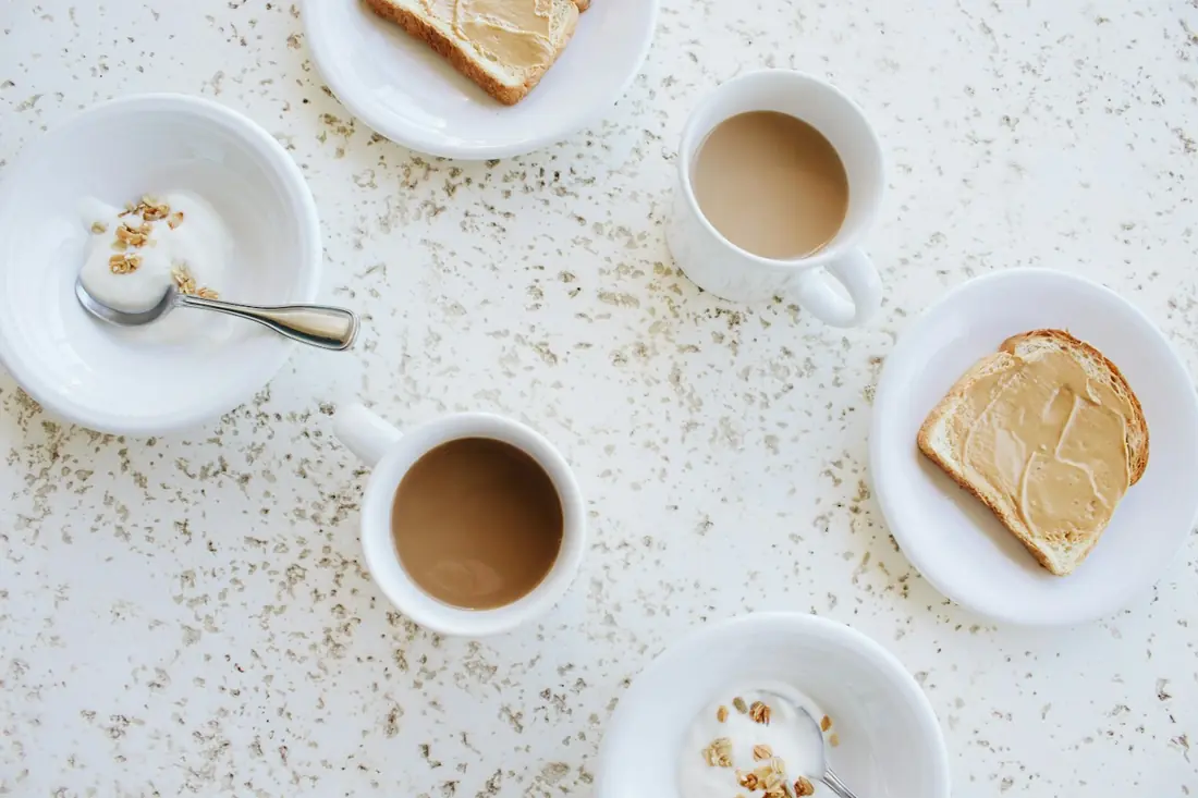 Torradas com manteiga e chávenas de café com leite